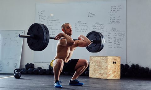 Man doing front squats shirtless