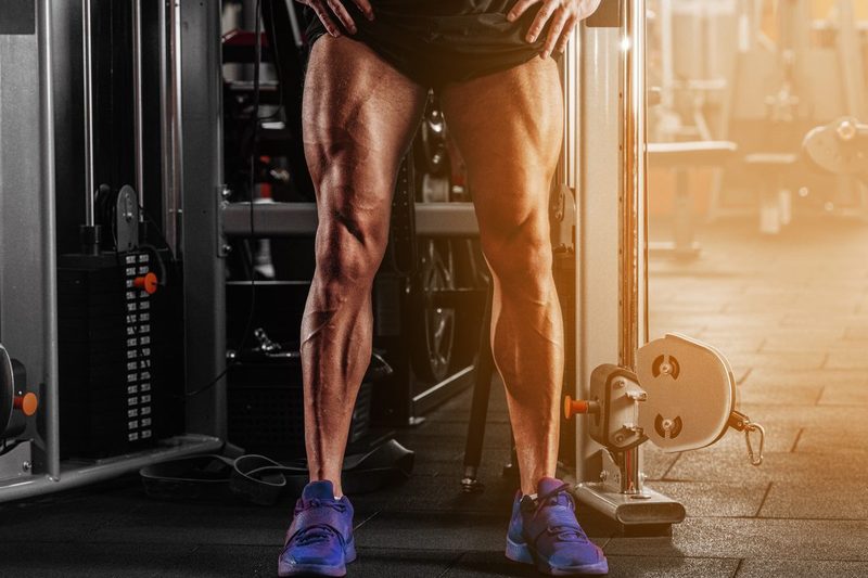 Man with strong legs by cable machine. muscular legs