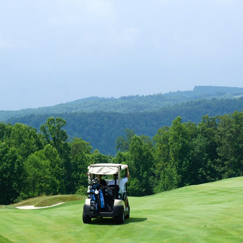 People riding a golf cart around the gofl course