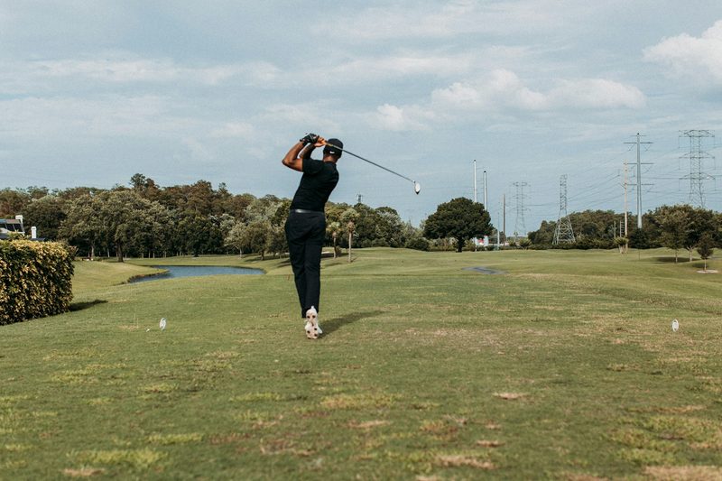 A golfer taking a swing on the golf course.