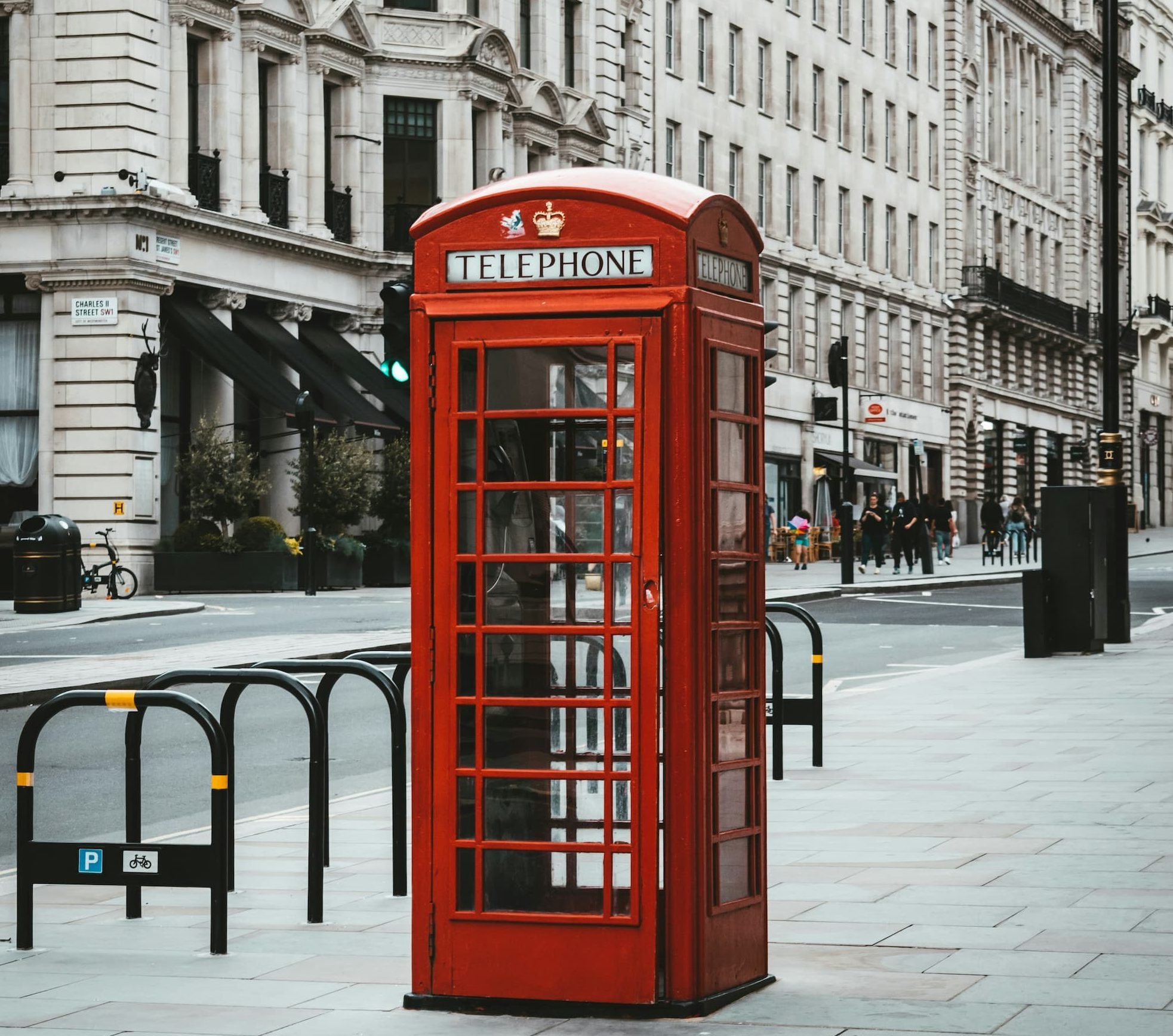red telephone booth next to white concrete building