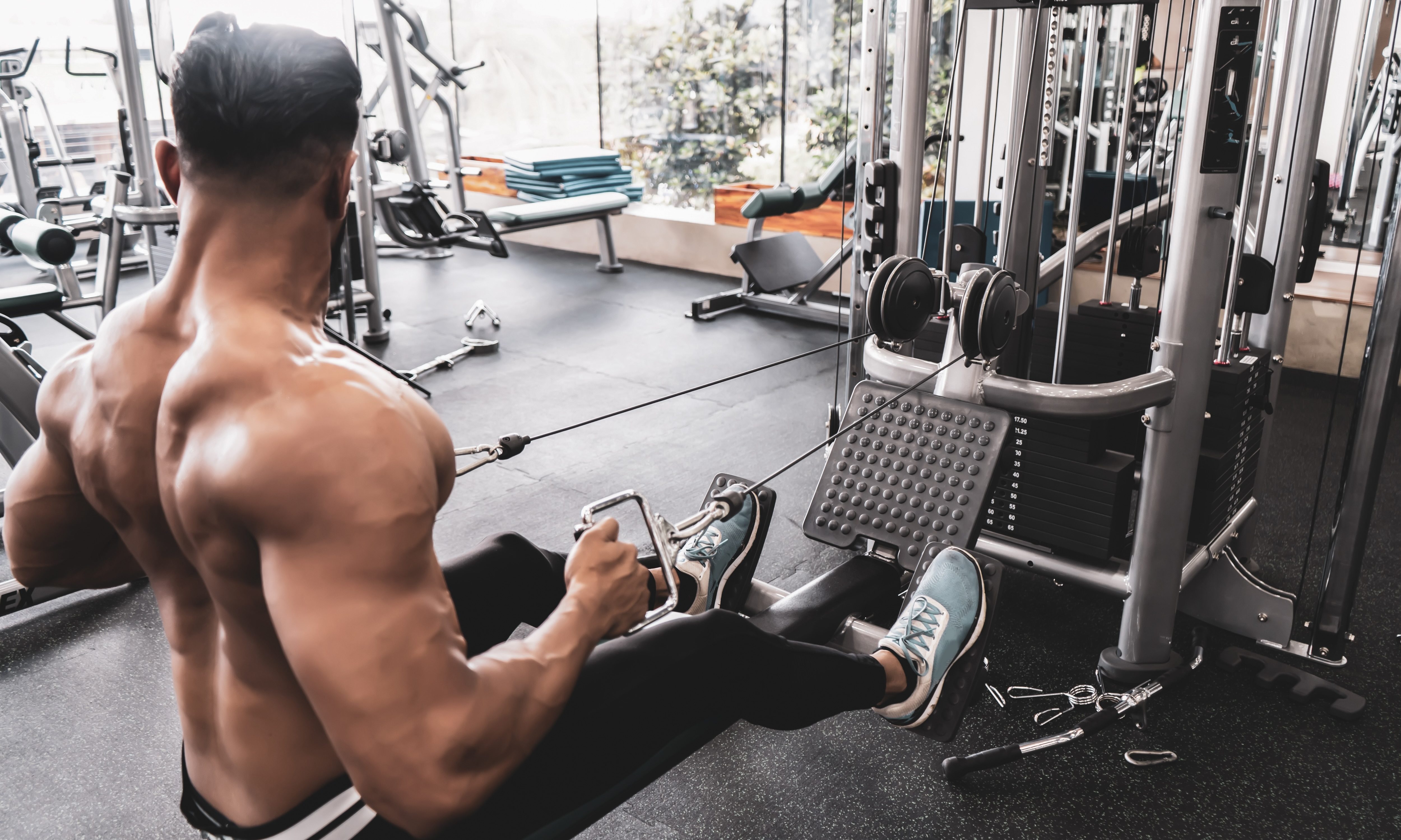 Athlete makes low cable pulley row seated in gym.