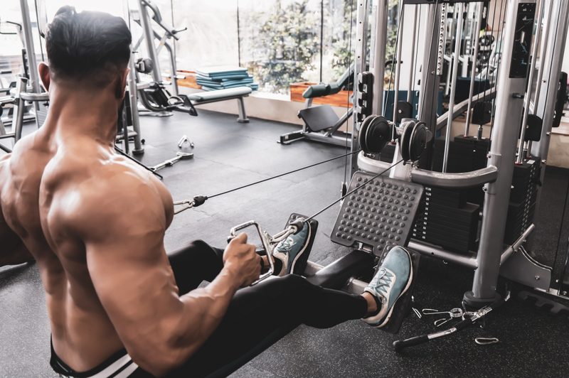 Athlete makes low cable pulley row seated in gym.