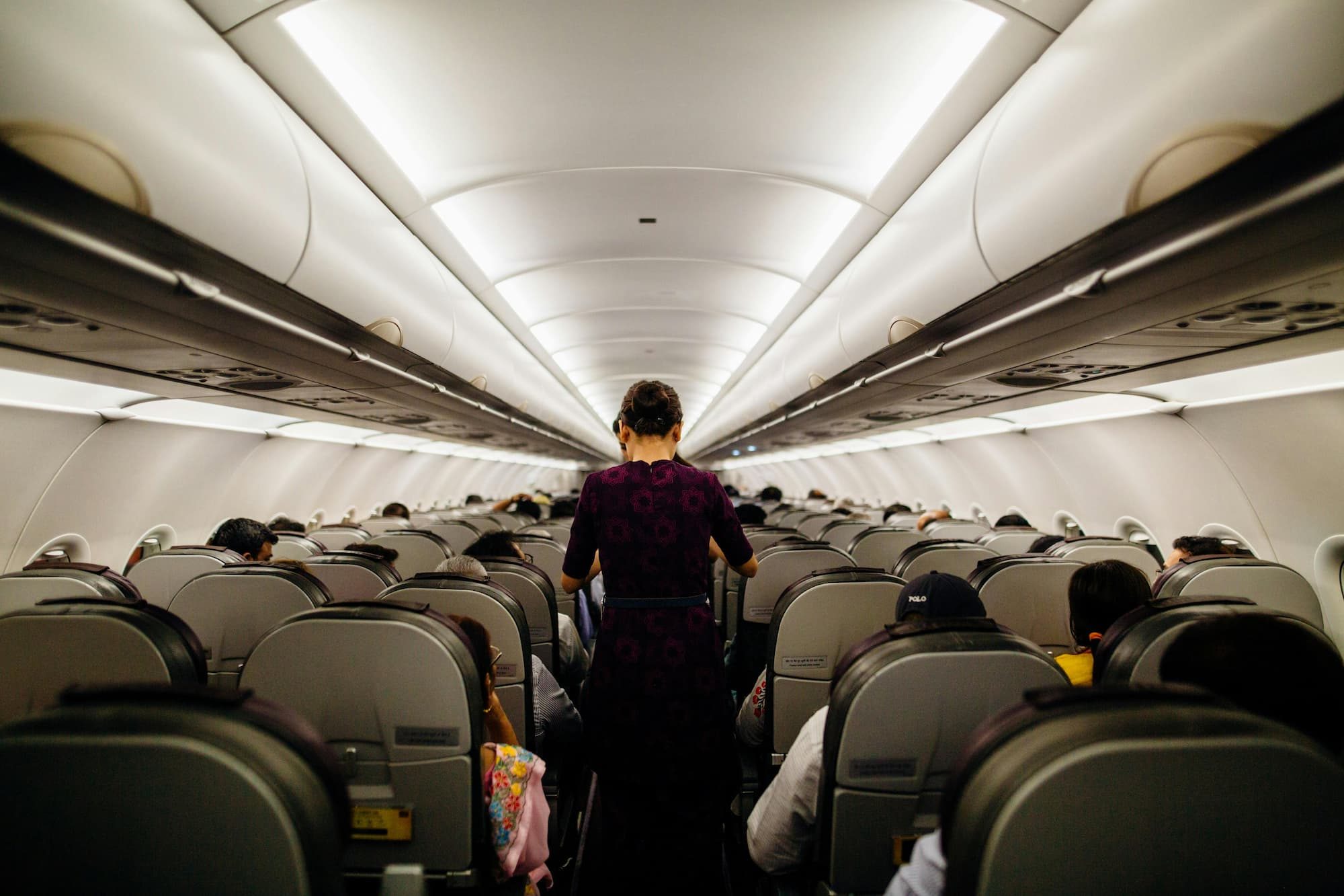 person walking down aisle in airplane