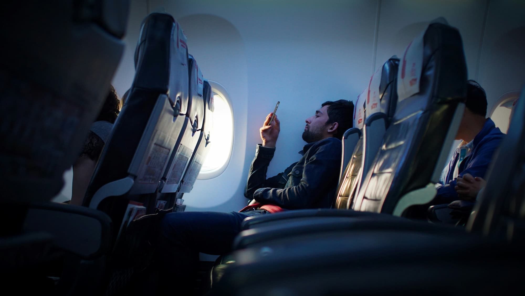 person sitting inside an airplane using phone