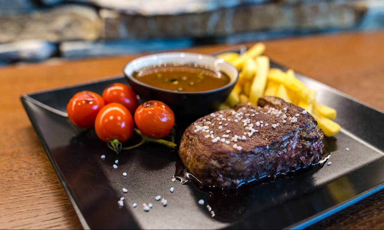 Steak with fries and tomatoes,