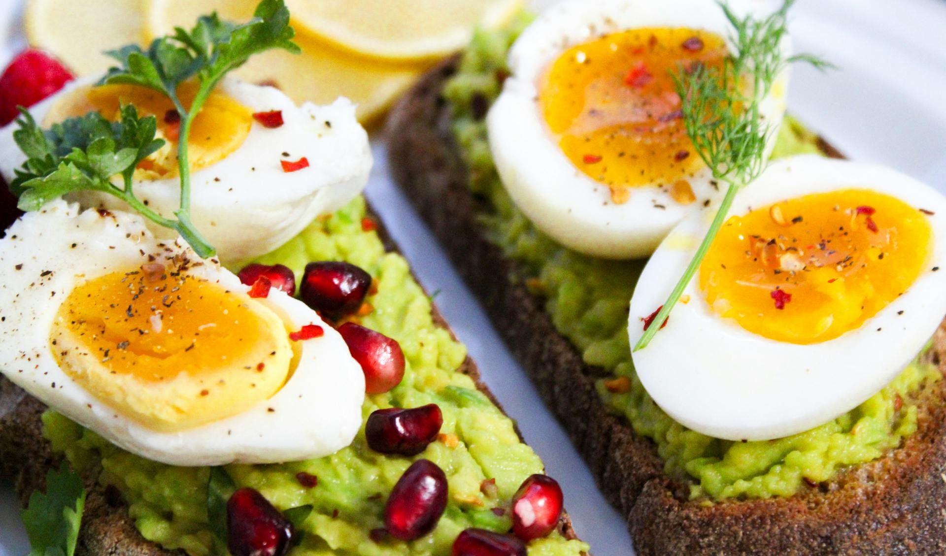 Boiled eggs sliced on avocado toast