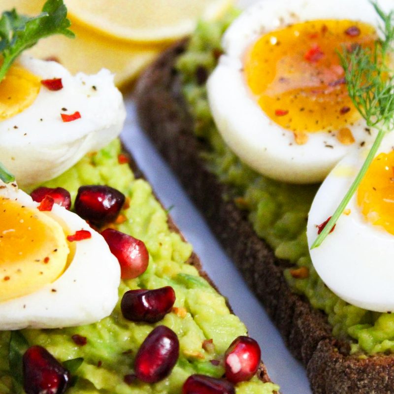 Boiled eggs sliced on avocado toast