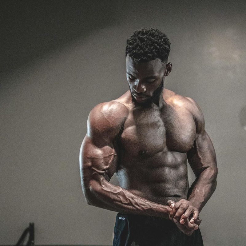 Muscular man with shirt off flexing muscles