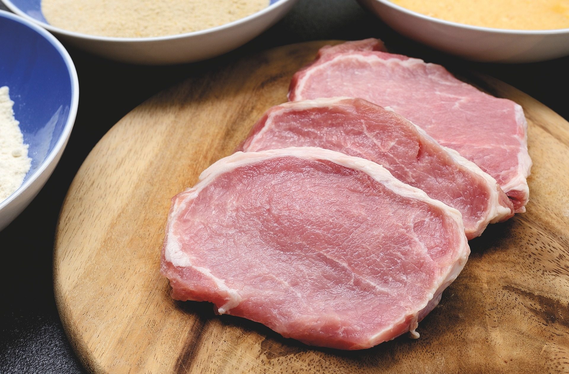 Raw pork chops on cutting board