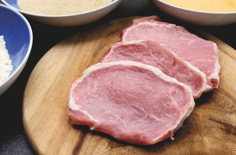 Raw pork chops on cutting board