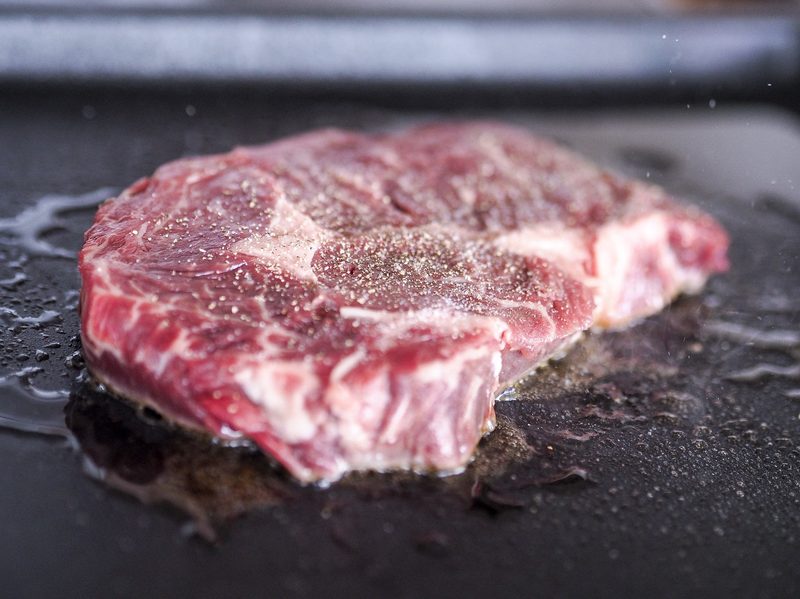 Steak cooking on flat top
