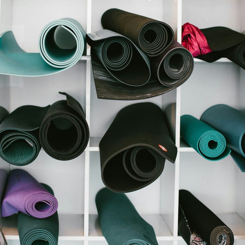 Rolled up yoga exercise mats in white shelves