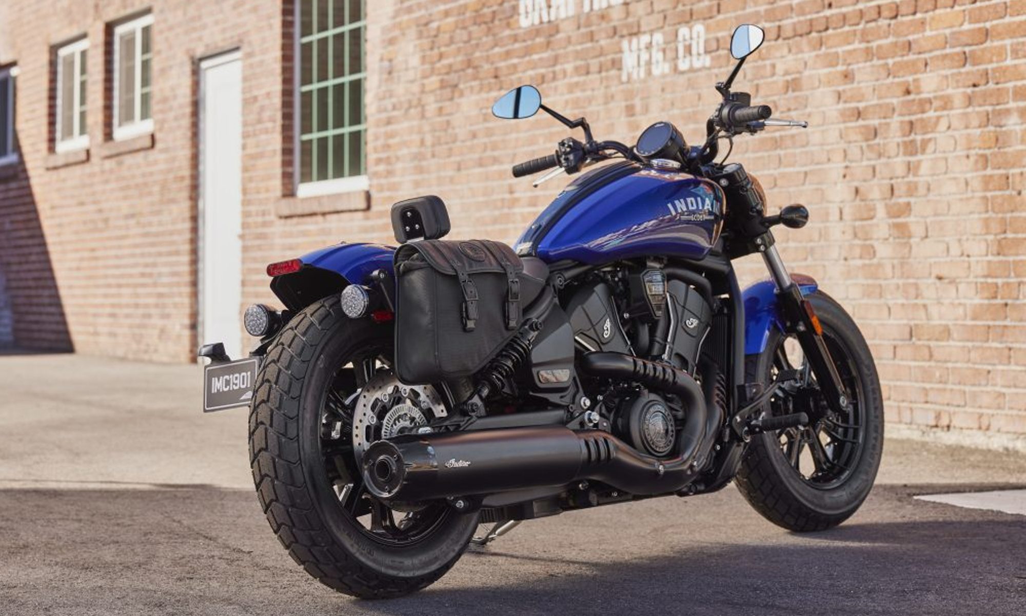 2025 Indian Motorcycle Scout Bobber parked by a restaurant right rear three-quarter view.