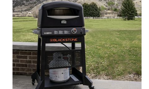 The Blackstone Outdoor Propane Pizza Oven in a back yard.