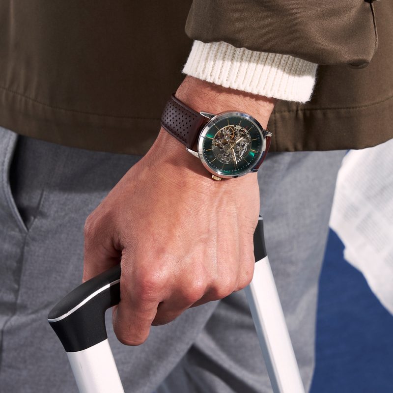 Man wearing Armitron watch pulling luggage
