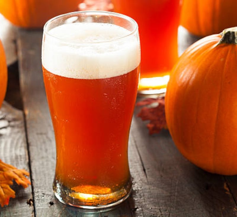Pumpkin beer next to pumpkins