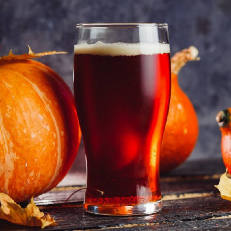 Pint of beer next to pumpkins