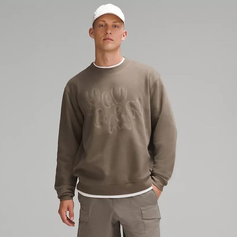 A man wears the roomy men's Lululemon Steady State Crew Embroidered sweater.