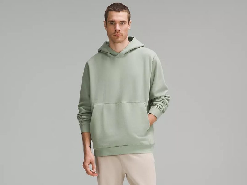 A man wears the popular light green Lululemon men's Steady State Hoodie.