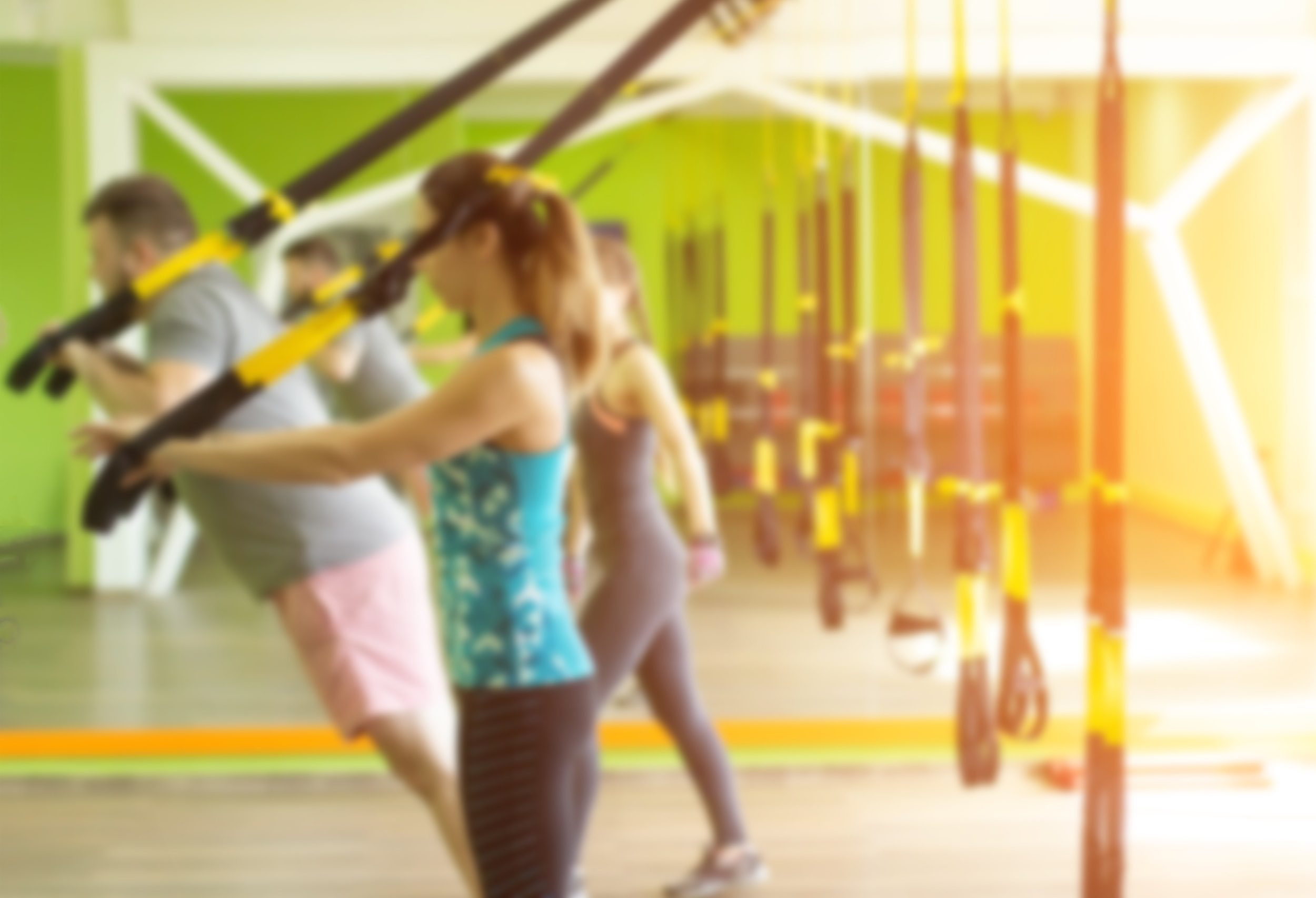 Suspension trainer tricep extension people in gym working out together