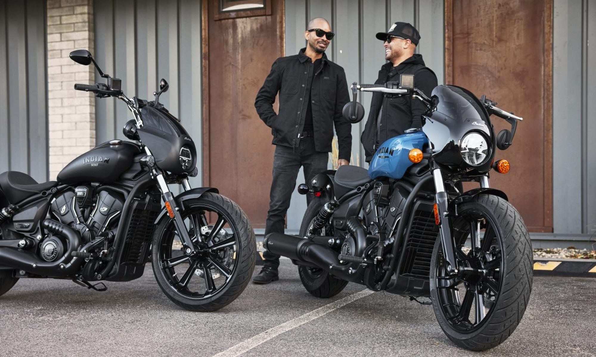 Two 2025 Indian Motorcycle Sport Scouts with two people standing behind them.
