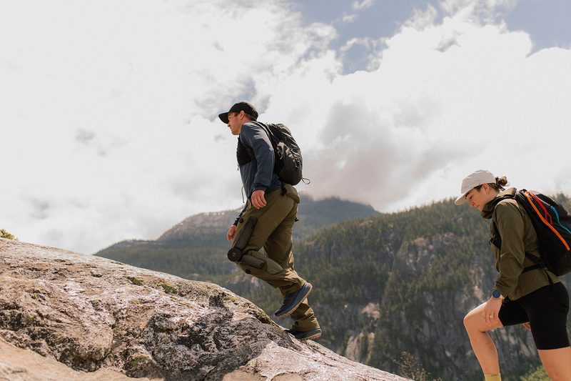 Hiker climbing a mountain wearing Arc'teryx's Mo/Go powered hiking pants.