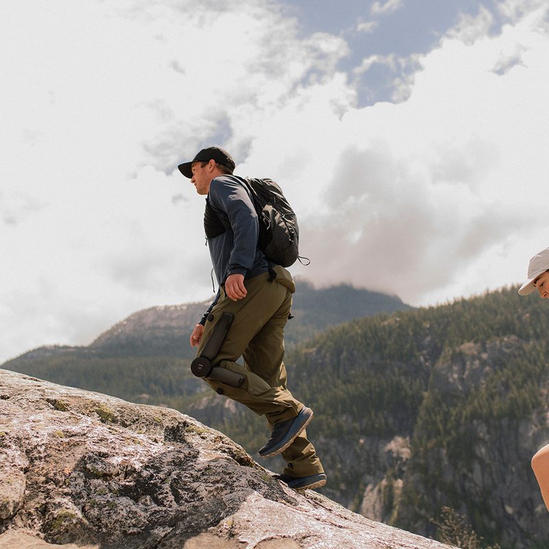 Hikers climbing a mountain wearing Arc'teryx's Mo/Go powered hiking pants.