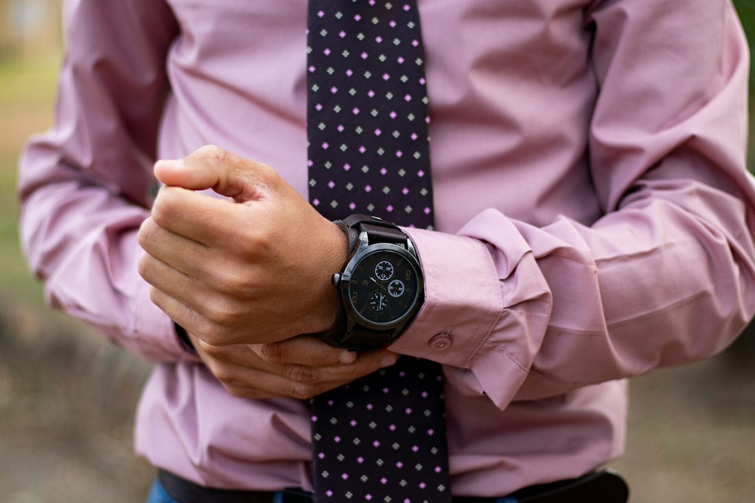 man wearing a watch and suit