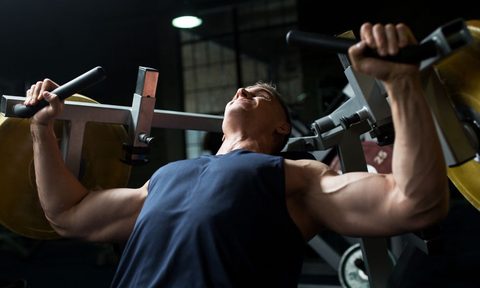 Man in a blue shirt using a chest press