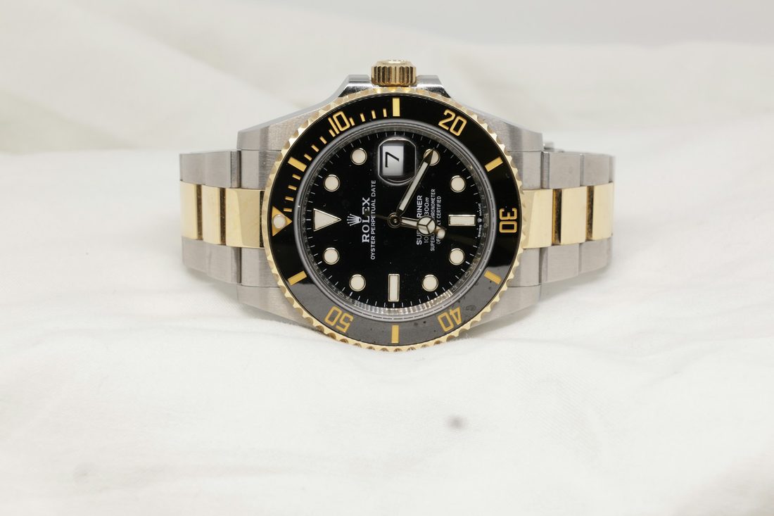 black Rolex laying on table