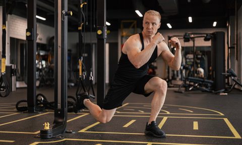 Man doing TRX Bulgarian split squats