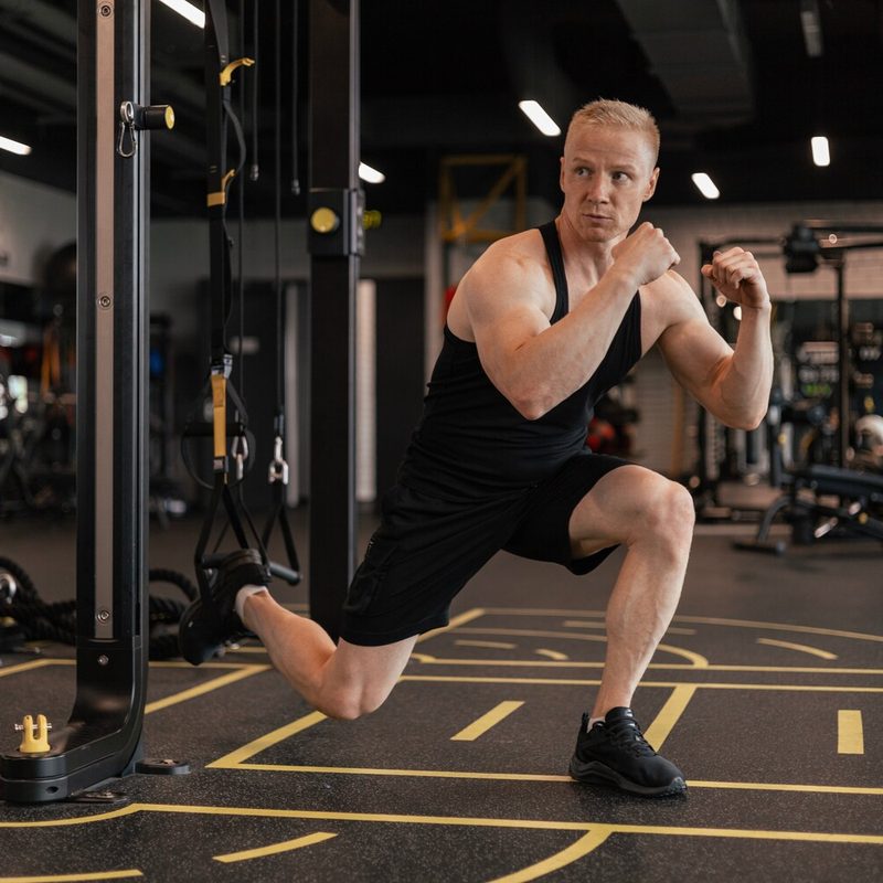 Man doing TRX Bulgarian split squats