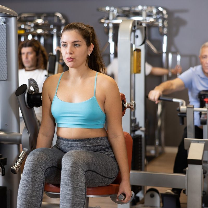 Woman using a back extension machine.