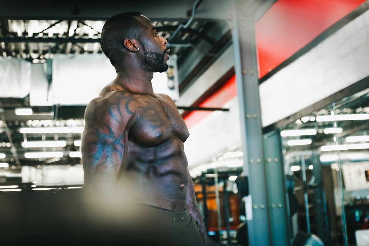 man with abs standing at the gym