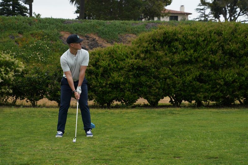 A golfer lining up their swing.