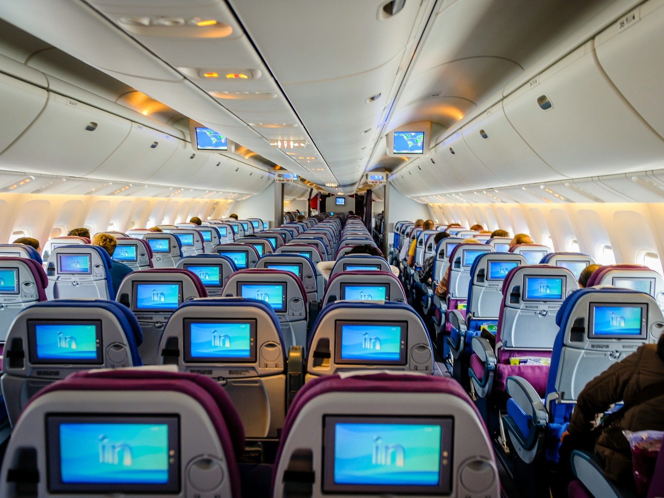 Inside of a plane with screens on