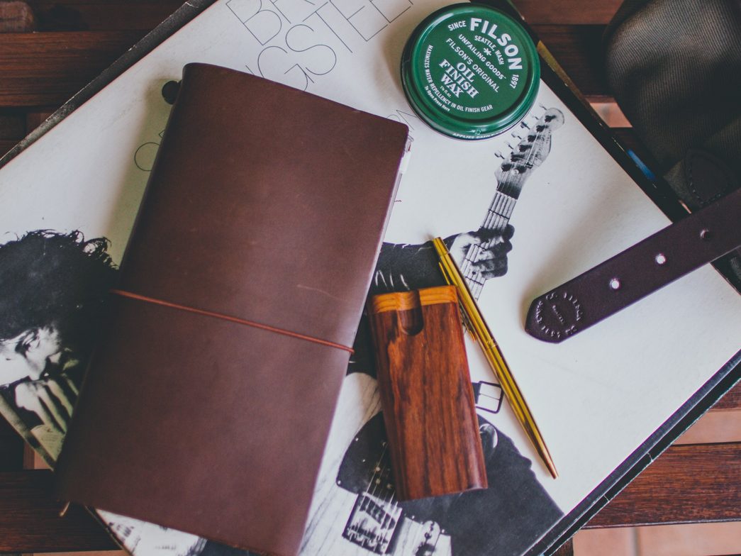 workspace with leather book and wax