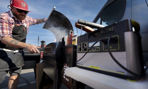 Man grilling while tailgating with a Goal Zero portable power station.