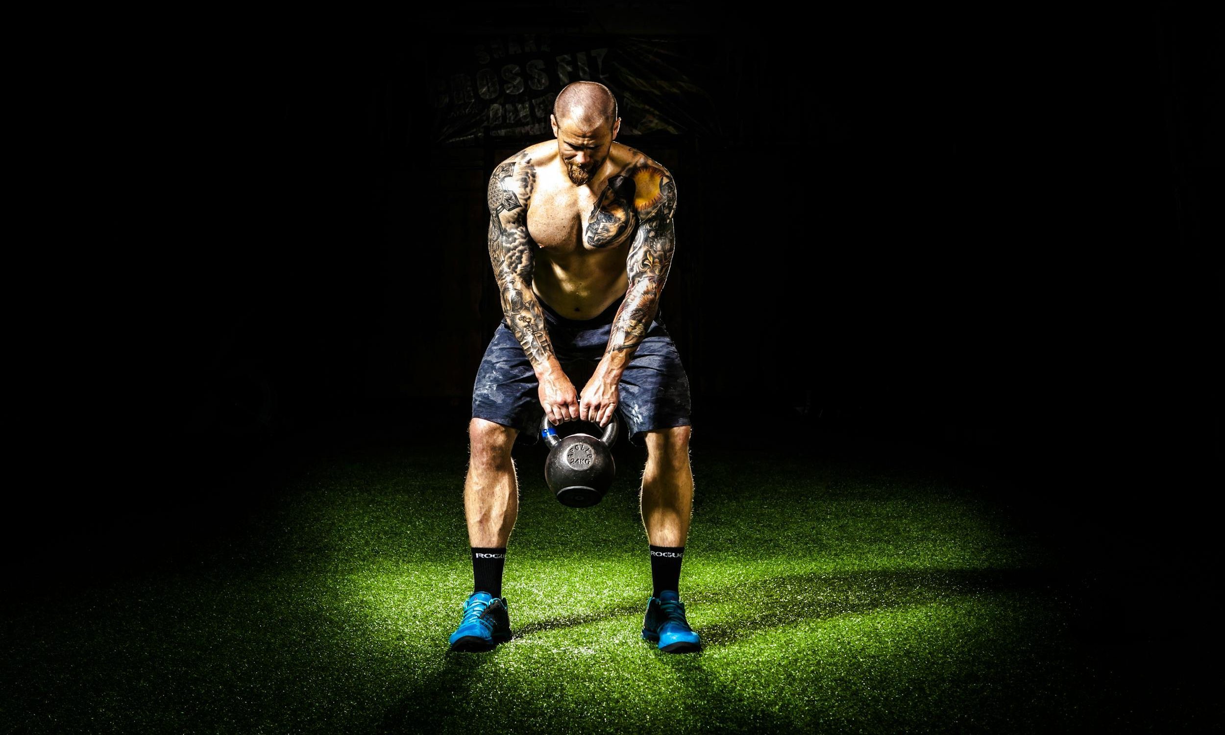 man swinging kettlebell with shorts blue shoes black background kettlebell swing pexels