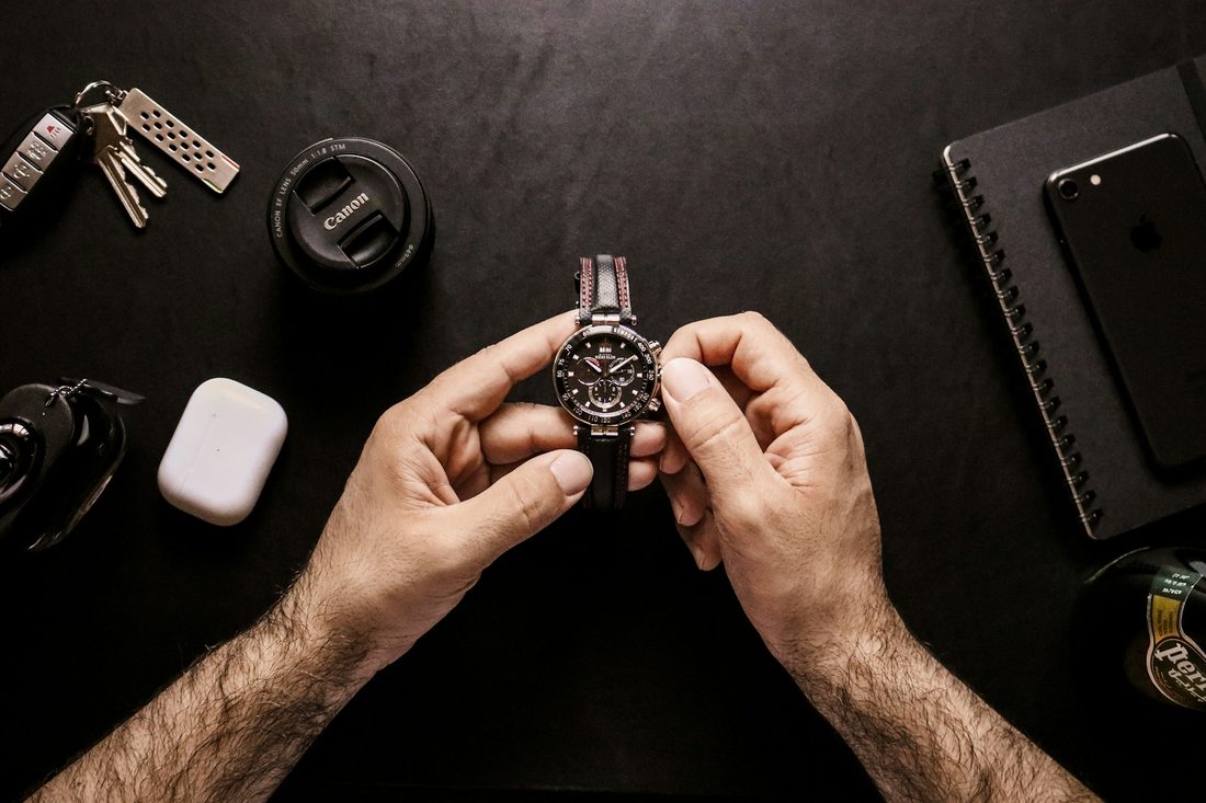 man winding a watch on table
