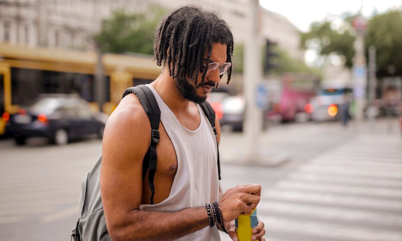 A person opening a canned drink while walking.