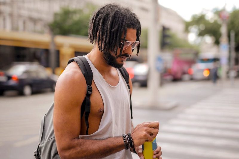 A person opening a canned drink while walking.