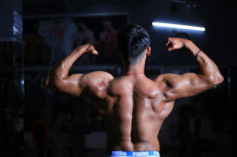 Shirtless man flexing back muscles