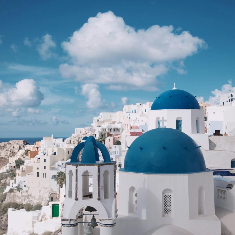 White buildings on a hill during the day in Santorini, Greece