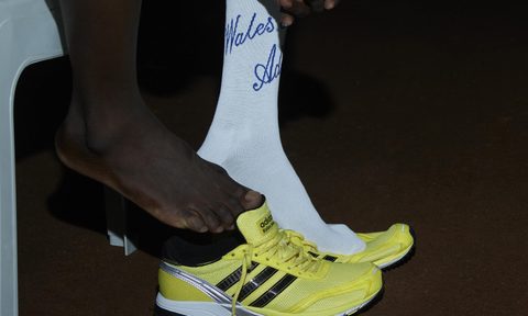 person taking off adidas neftenga shoe in dark,