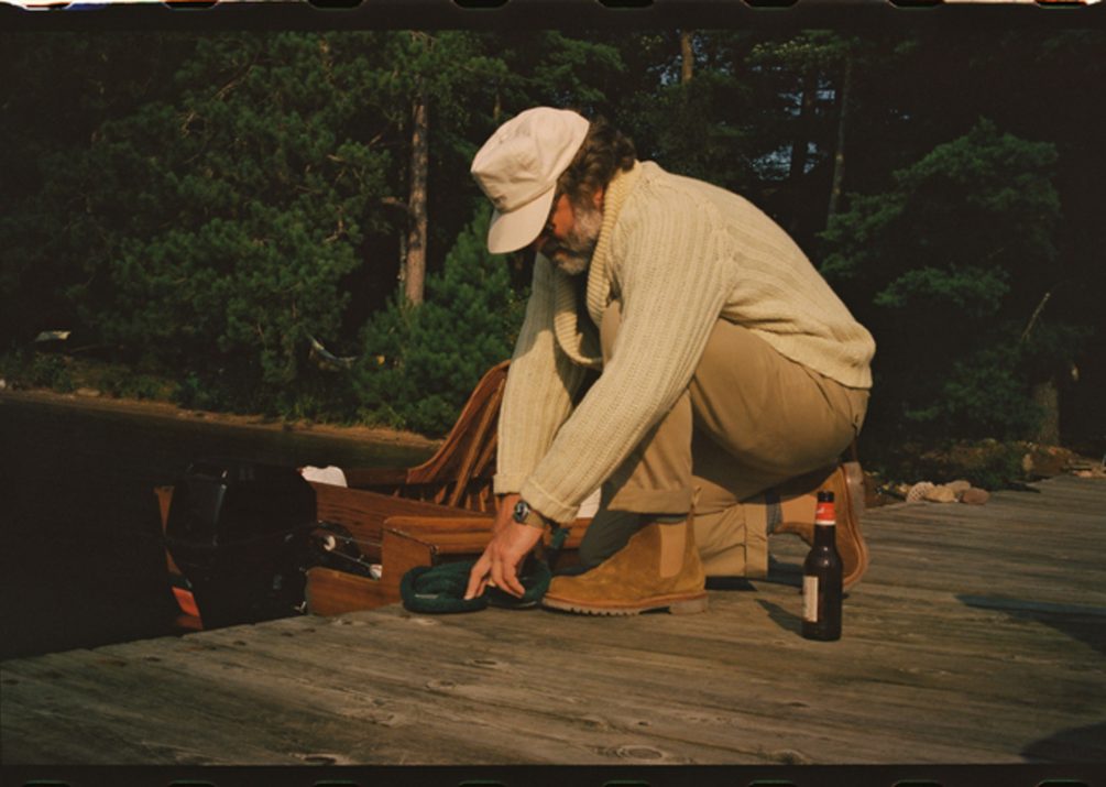 man sitting on dock wearing suede boots