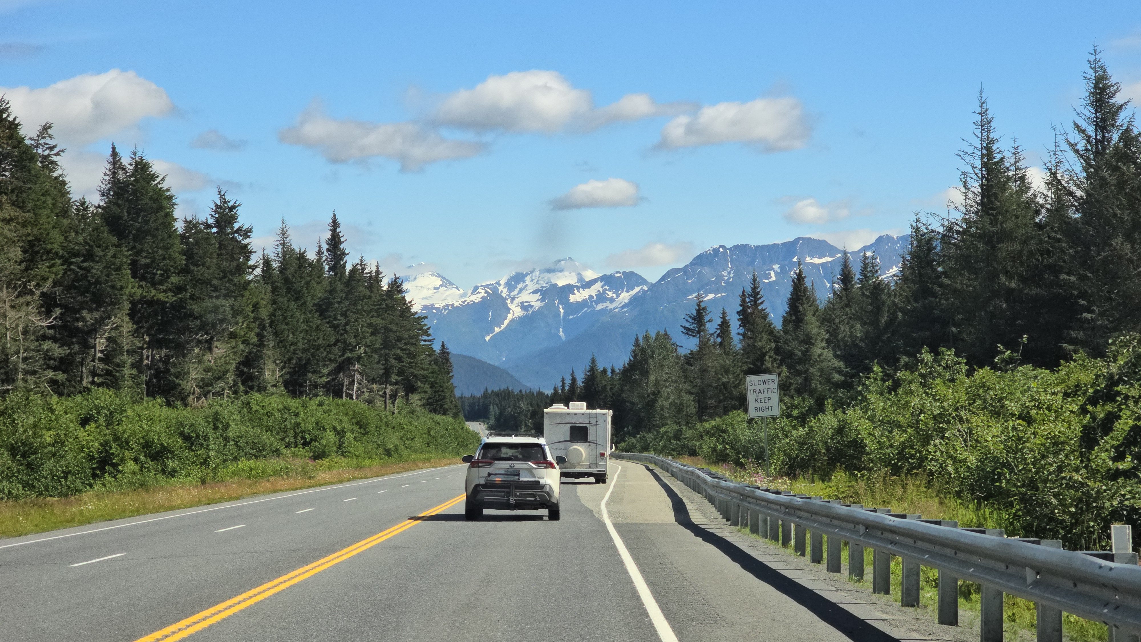 A road leading to Alaska with mountains in the background