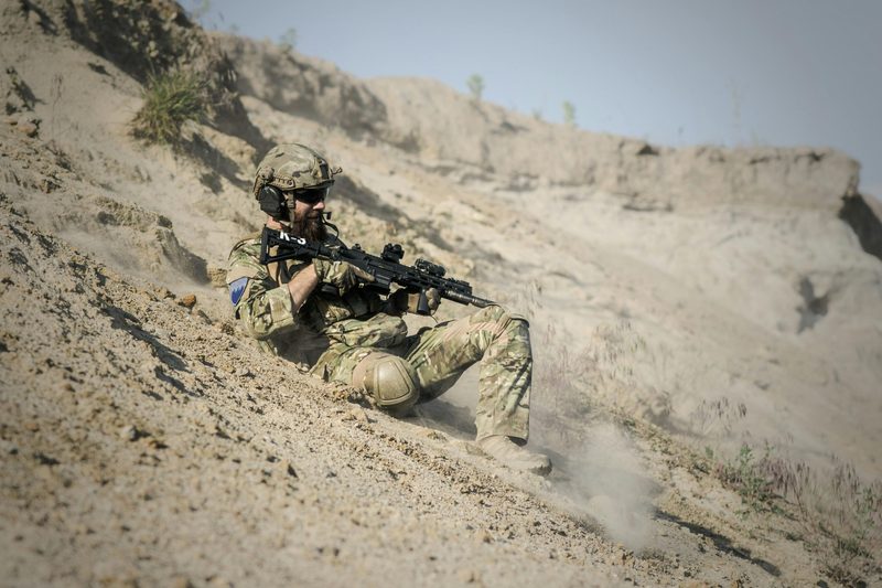 Army soldier sliding down hill