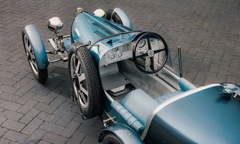 BUGATTI Baby II Tourbillon Edition parked on a stone-paved surface left side overhead view of the cockpit.